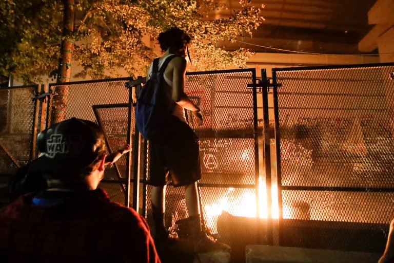 Demonstrators light a fire during a Black Lives Matter protest at the Mark O. Hatfield United States Courthouse Monday, July 27, 2020, in Portland, Ore.
