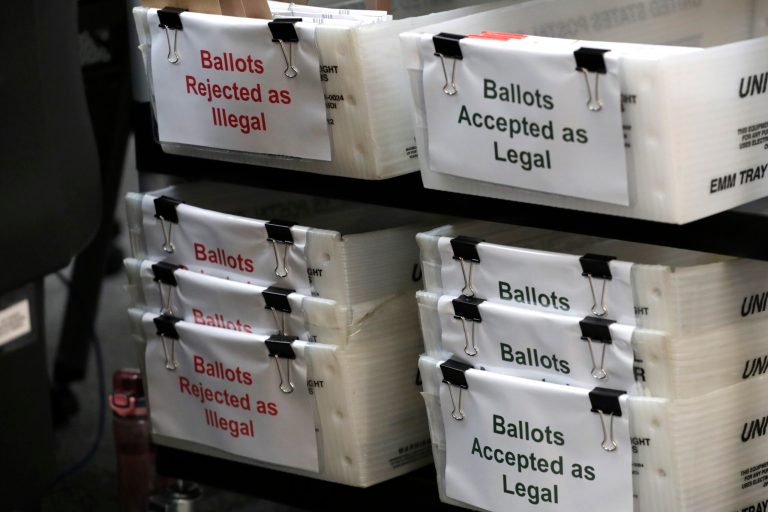 Boxes for illegal and legal vote-by-mail ballots are shown as the the Miami-Dade County canvassing board meets to verify signatures on vote-by-mail ballots for the August 18 primary election. President Trump has questioned mail-in voting.