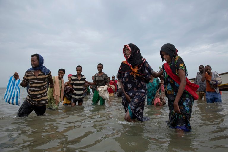 In this July 26, 2019 file photo, Ethiopian migrants disembark from a boat onto the shores of Ras al-Ara, Lahj, Yemen, determined to reach oil-rich Saudi Arabia.