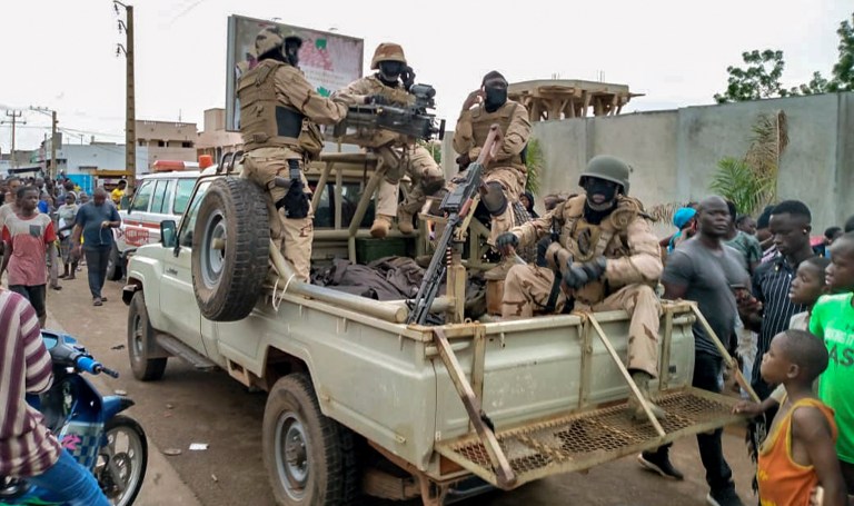 Malian troops and citizens gather outside the private residence of Mali's President Ibrahim Boubacar Keita in Bamako, Mali Tuesday, Aug. 18, 2020. Mutinous soldiers surrounded the private residence of Keita on Tuesday, firing shots into the air and a West African regional official confirmed that the president and prime minister had been detained, following several months of demonstrations calling for his resignation.
