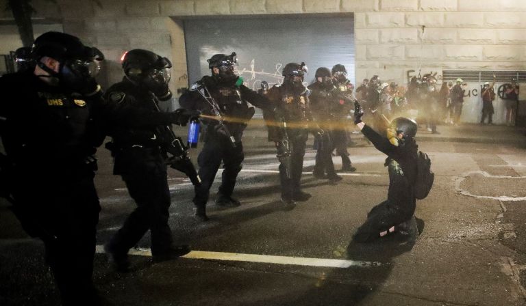 In this file photo, a demonstrator is pepper sprayed shortly before being arrested during a Black Lives Matter protest at the Mark O. Hatfield United States Courthouse in Portland, Ore. The American Civil Liberties Union has filed a federal lawsuit Wednesday, Aug. 26, 2020, challenging the legality of the actions taken by U.S. agents sent by President Donald Trump to subdue protests in Portland.