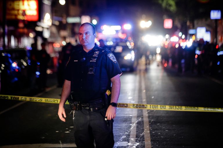 In the June 4, 2020, photo, a New York City police officer stands on a street at the scene of a shooting in the Brooklyn borough of New York. Dzenan Camovic was indicted on Wednesday, Aug. 26, 2020, for ambushing a New York City police officer on June 4, stabbing him in the neck, and stealing his gun to shoot other officers.