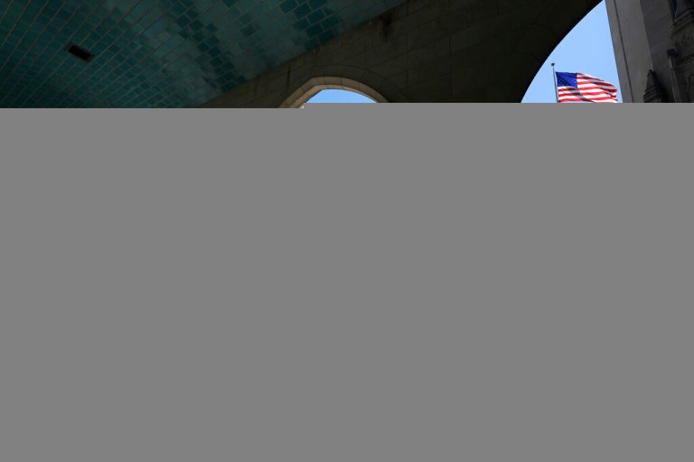 In this May 20, 2020 file photo, a runner passes through an arch on the campus of Boston University in Boston. 