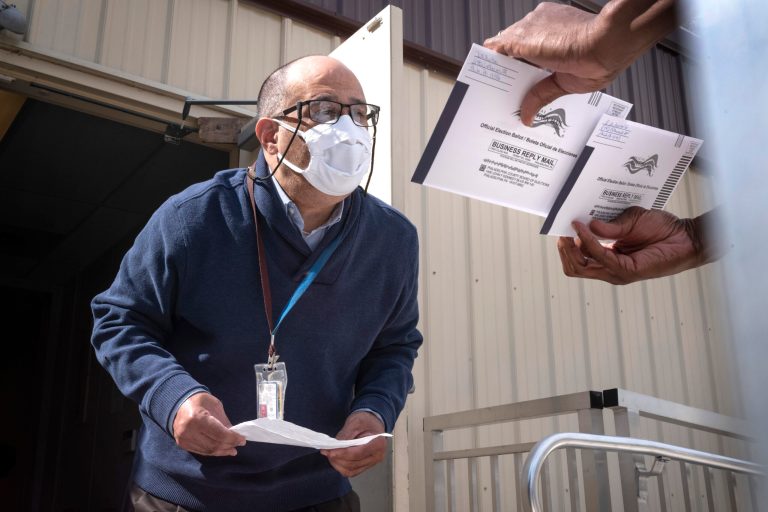 An employee of the Philadelphia Commissioners Office examines ballots at a satellite election office at Overbrook High School in Philadelphia. Americans are concerned about the upcoming election vote.