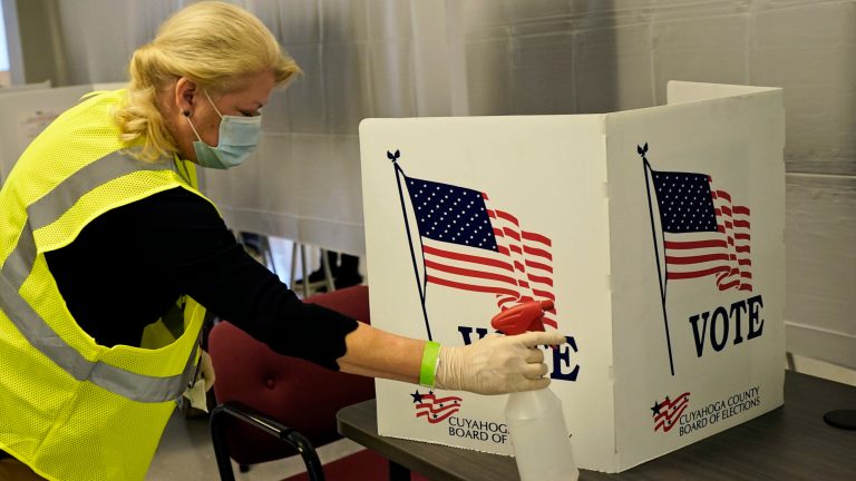 Pat DeVito cleans a voting booth during early voting at the Cuyahoga County Board of Elections, Tuesday, Oct. 6, 2020, in Cleveland. The head of the Federal Election Commission said voting in person is the best way to guarantee your vote counts.