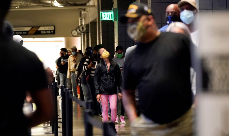 People wait in a line to vote early at the State Farm Arena on Monday, Oct. 12, 2020, in Atlanta.