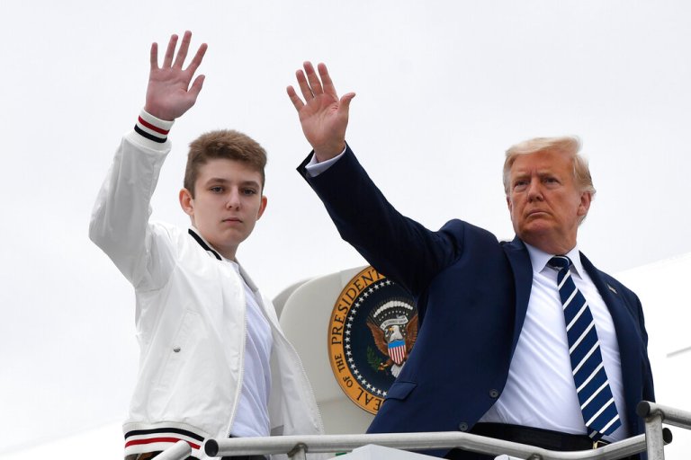FILE - In this Aug. 16, 2020 file photo, President Donald Trump, right, and his son Barron Trump wave from the top of the steps to Air Force One at Morristown Municipal Airport in Morristown, N.J. 