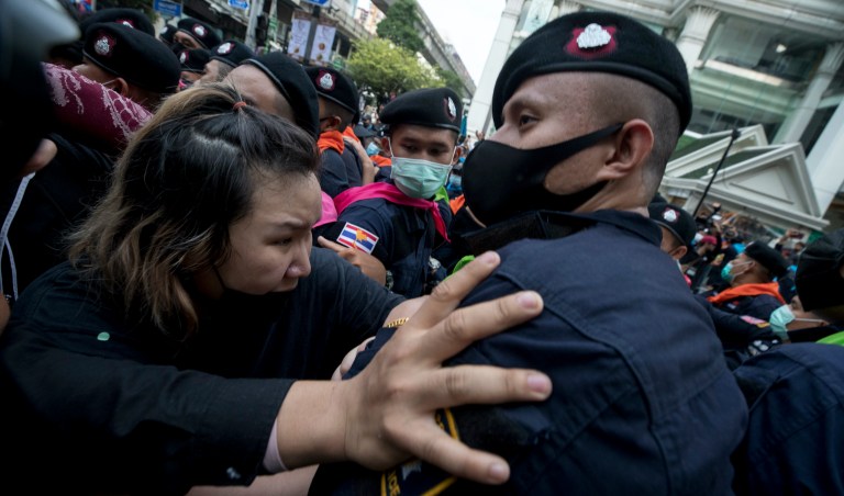 Police official scuffle with pro-democracy protesters during a protest as they occupied the main road in the central business district in Bangkok, Thailand, Thursday, Oct. 15, 2020. Thailand's government declared a strict new state of emergency for the capital on Thursday, a day after a student-led protest against the country's traditional establishment saw an extraordinary moment in which demonstrators heckled a royal motorcade. (AP Photo/Wason Wanichakorn)