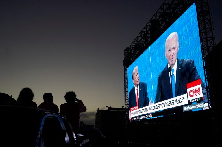 People watch from their vehicle as President Donald Trump, on left of video screen, and Democratic presidential candidate former Vice President Joe Biden speak during a Presidential Debate Watch Party at Fort Mason Center in San Francisco, Thursday, Oct. 22, 2020.