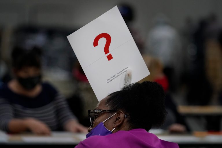 An officials holds up a question sign signifying there is a question about a ballot during an audit at the Georgia World Congress Center on Saturday, Nov. 14, 2020, in Atlanta. Conservatives are moving to tighten election rules.
