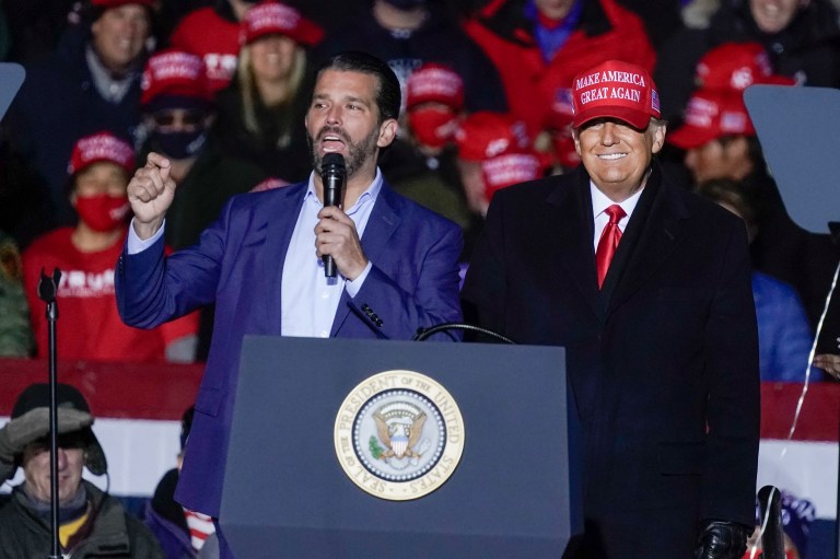 Former President Donald Trump watches as Donald Trump Jr. speaks at a pre-election campaign event at the Kenosha Regional Airport in Kenosha, Wis. Trump son said the Senate impeachment trial is making his father stronger politically.