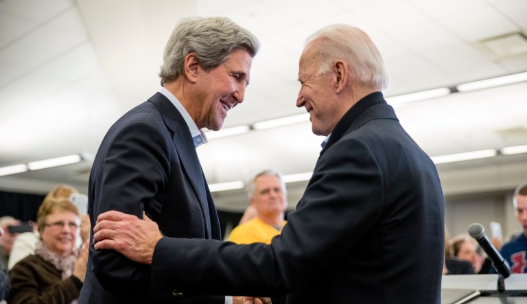 In this Feb. 1, 2020, file photo Democratic presidential candidate former Vice President Joe Biden smiles as former Secretary of State John Kerry, left, takes the podium to speak at a campaign stop at the South Slope Community Center in North Liberty, Iowa.