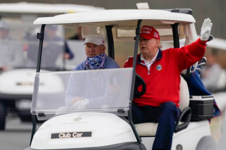 President Donald Trump drives a golf cart as he plays golf at Trump National Golf Club, Friday in Sterling, Va.