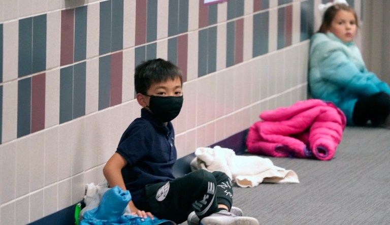 Elementary school students wait in the hallway at Tibbals Elementary School in Murphy, Texas, Thursday, Dec. 3, 2020. Texas Gov. Greg Abbot's statewide mask order does not mandate face covering for children under the age of 10, allowing some school districts to not require masks for children leaving the choice of mask use up to the parents.