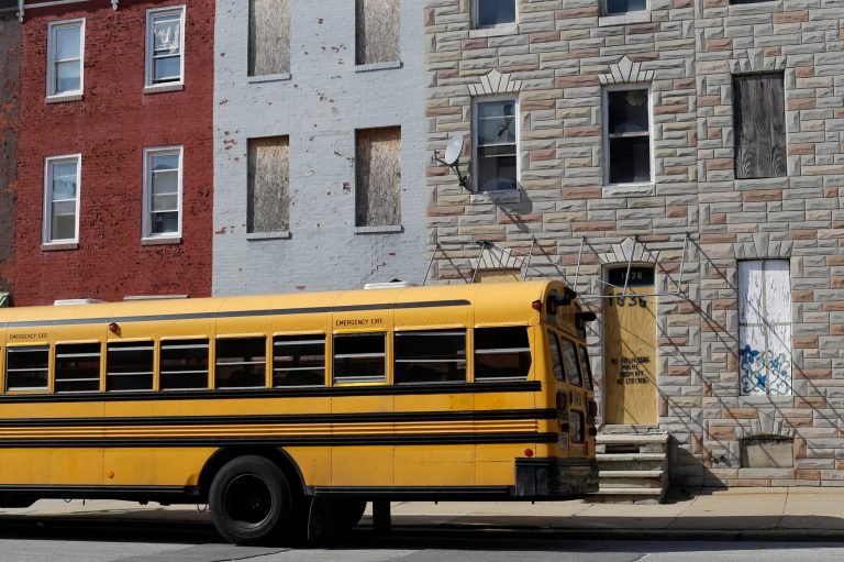 A school bus sits near blighted row houses in Baltimore.