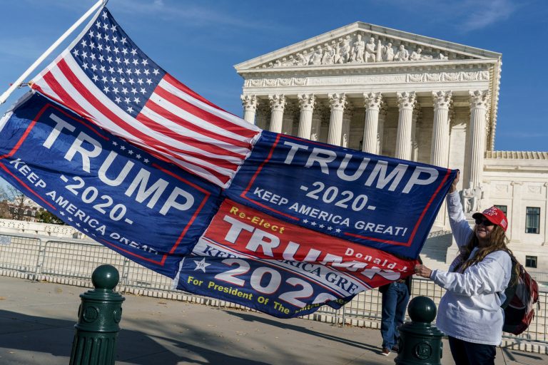Kathy Kratt of Orlando, Fla., displays her Trump flags as she and other protesters demonstrate their support for President Donald Trump at the Supreme Court in Washington, Friday, Dec. 11, 2020. The court yesterday rejected Trump's latest election challenge.