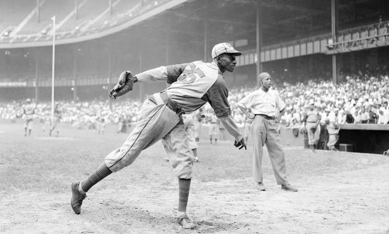 FILE - In this Aug. 2, 1942, file photo, Kansas City Monarchs pitcher Leroy Satchel Paige warms up at New York's Yankee Stadium before a Negro League game between the Monarchs and the New York Cuban Stars.  Major League Baseball has reclassified the Negro Leagues as a major league and will count the statistics and records of its 3,400 players as part of its history. The league said Wednesday, Dec. 16, 2020, it was âcorrecting a longtime oversight in the game's historyâ by elevating the Negro Leagues on the centennial of its founding.  (AP Photo/Matty Zimmerman, File)
