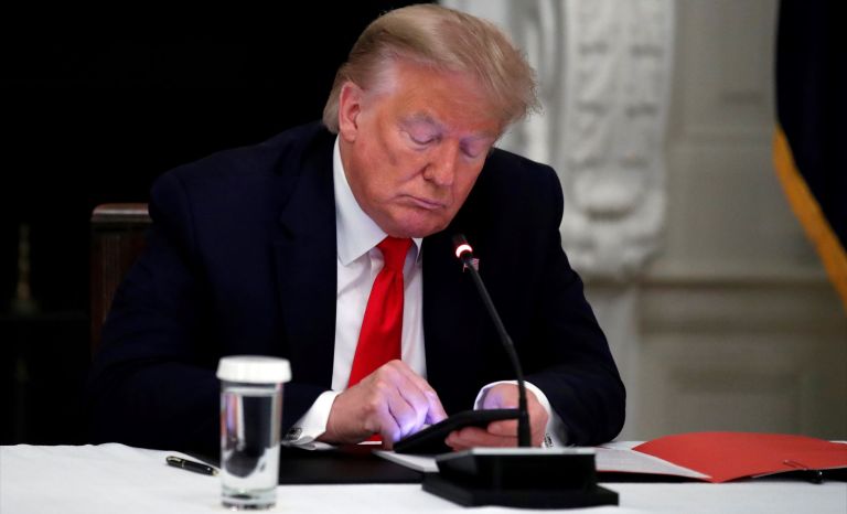 President Trump checks his phone during a meeting with governors in this June 2020 picture. (AP Photo/Alex Brandon, File)