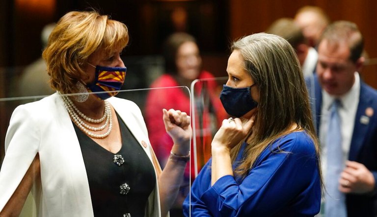 Rep. Regina Cobb, R-Kingman, left, and Rep. Shawnna Bolick, R-Phoenix, wear facing coverings due to COVID-19, during the opening of the Arizona Legislature at the state Capitol, Monday, Jan. 11, 2021, in Phoenix.