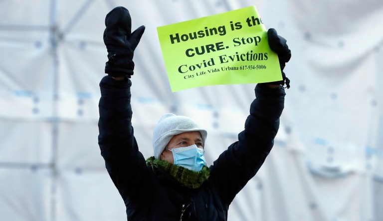 A tenants' rights advocate demonstrates outside the Edward W. Brooke Courthouse, Wednesday, Jan. 13, 2021, in Boston. The protest was part of a national day of action calling on the incoming Biden administration to extend the eviction moratorium initiated in response to the Covid-19 pandemic.