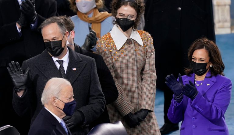 Vice President-elect Kamala Harris applauds with husband Doug Emhoff, left, and her stepdaughter Ella Emhoff as President-elect Joe Biden arrives for the 59th Presidential Inauguration, Jan. 20, 2021.