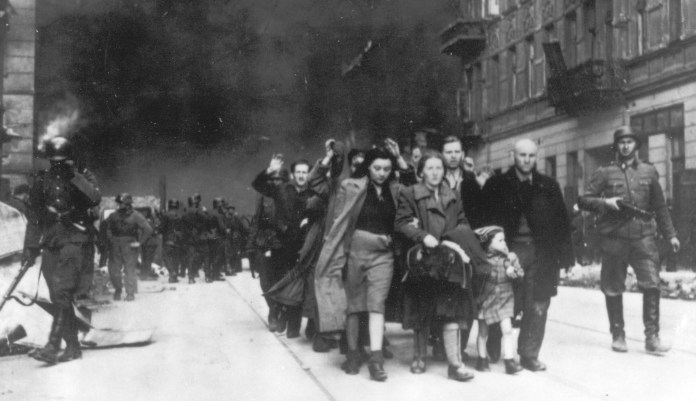 In this 1943 file photo, a group of Polish Jews are led away for deportation by German SS soldiers during the destruction of the Warsaw Ghetto by German troops after an uprising in the Jewish quarter. A Warsaw court is scheduled to deliver a verdict Tuesday, Feb. 9, 2021 in a closely watched libel case in which Polish national dignity and the independence of Holocaust research are said to be at stake.