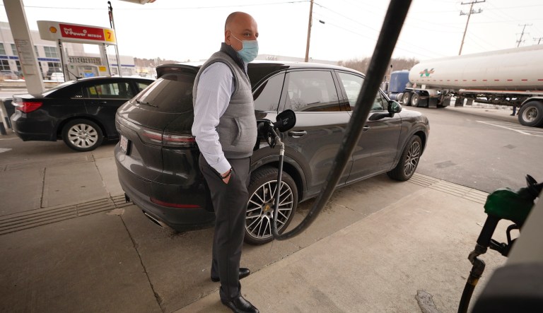 Jeremy Heskett, of Boston, pours gasoline at a Shell gas station, Thursday, Feb. 18, 2021, in Westwood, Mass.  Energy prices declined for a second day, as the frigid temperatures that impacted Texas and much of the Midwest moved east. Natural gas prices were down 4%. Energy prices have been volatile the past week as record demand for natural gas and other fossil fuels to warm homes has caused electricity prices to skyrocket. Natural gas is typically used as an âon-demandâ fuel source to cover increased electrical needs.