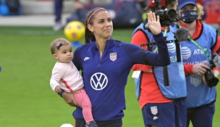 United States forward Alex Morgan (13) waves to fans in the stands while holding her daughter Charlie Elena Carrasco after a SheBelieves Cup women's soccer match against Brazil, Sunday, Feb. 21, 2021, in Orlando, Fla.