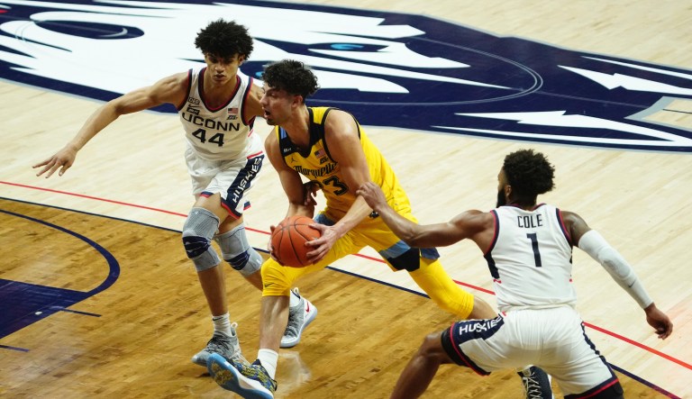 Marquette forward Dawson Garcia (33) drives against Connecticut Huskies guard Andre Jackson (44) and guard R.J. Cole (1) in the second half of an NCAA college basketball game Saturday, Feb. 27, 2021, in Storrs, Conn.
