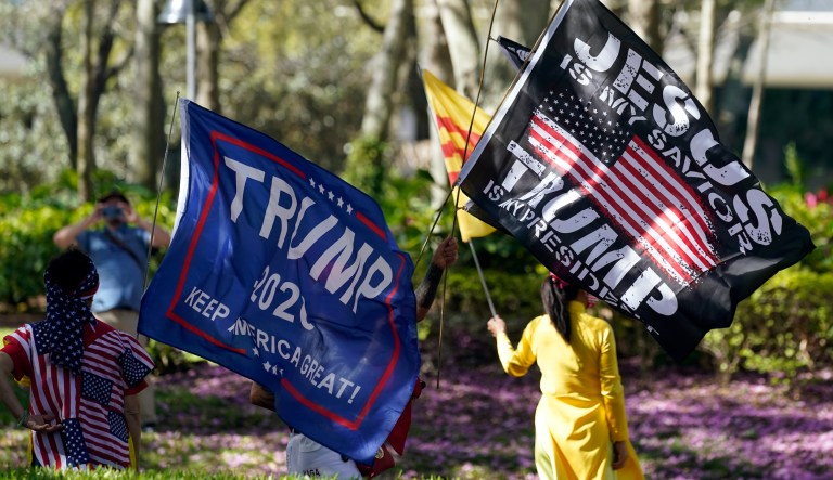 Donald Trump supporters wave flags outside the convention center at the Conservative Political Action Conference (CPAC) Sunday, Feb. 28, 2021, in Orlando, Fla.