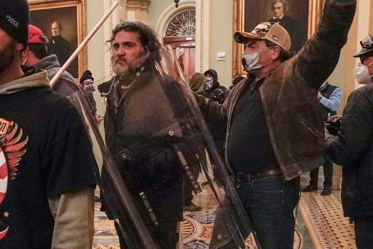 In this Jan. 6, 2021, photo, rioters, including Dominic Pezzola, center with police shield, are confronted by U.S. Capitol Police officers outside the Senate Chamber inside the Capitol, Wednesday, Jan. 6, 2021, in Washington. 