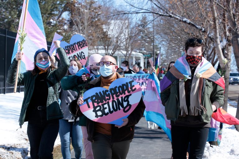 Advocates for transgender people march from the South Dakota governor's mansion to the Capitol in Pierre, S.D., on March 11, to protest a proposed ban on transgender girls and women from female sports leagues.