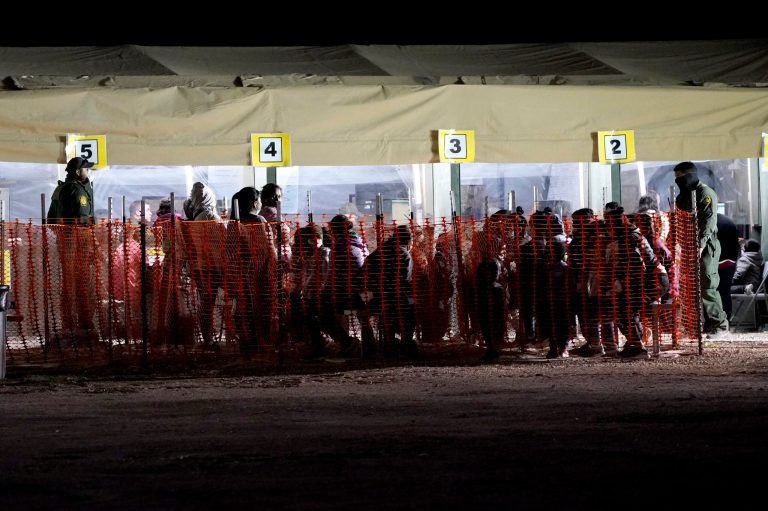 On Friday, migrants are seen in custody at a U.S. Customs and Border Protection processing area under the Anzalduas International Bridge, in Mission, Texas. The Biden administration is facing growing questions about why it wasn't more prepared for an influx of migrants at the southern border. The administration is scrambling to build up capacity to care for 14,000 young undocumented migrants now in federal custody â and more likely on the way.