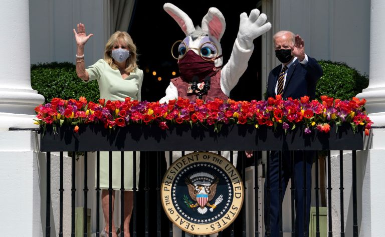 President Joe Biden and first lady Jill Biden wave from the Blue Room Balcony as they participate in an Easter event at the White House, Monday, April 5, 2021, in Washington. The annual East Egg Roll at the White House was cancelled due to the ongoing pandemic.