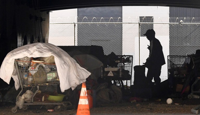 In this May 21, 2020, file photo, a man is seen at a homeless encampment that sits under Interstate 110 near Ramirez Street during the coronavirus outbreak in downtown Los Angeles.