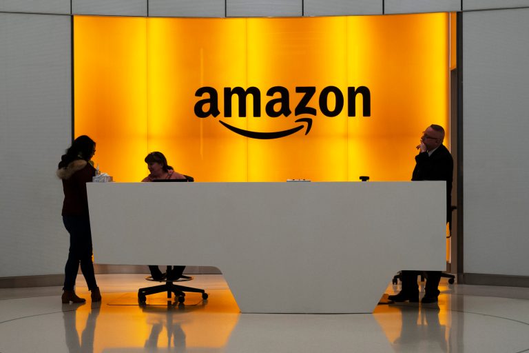 FILE - In this Feb. 14, 2019, file photo, people stand in the lobby for Amazon offices in New York. (AP Photo/Mark Lennihan, File)