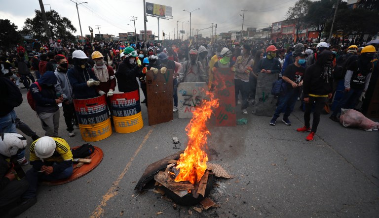 Protesters stand with their shields during an anti-government protest in Bogota, Colombia, Friday, May 28, 2021. Colombians have taken to the streets for weeks across the country after the government proposed tax increases on public services, fuel, wages and pensions.