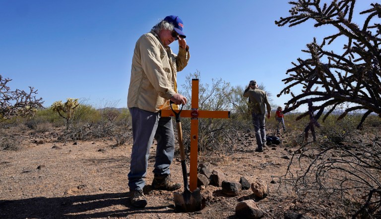 Alvaro Enciso, part of the Tucson Samaritans volunteer group, pauses as he and a group of volunteers place a new cross at the site of the migrant who died in the desert some time ago, shown here Tuesday, May 18, 2021, in the desert near Three Points, Ariz. 