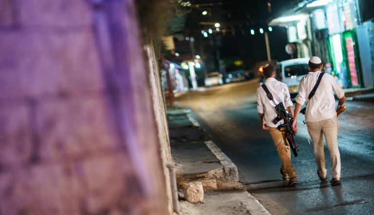 Jews walk through the street with guns in the mixed Arab-Jewish town of Lod, central Israel, Friday, May 28, 2021, in the wake of clashes between the two groups.