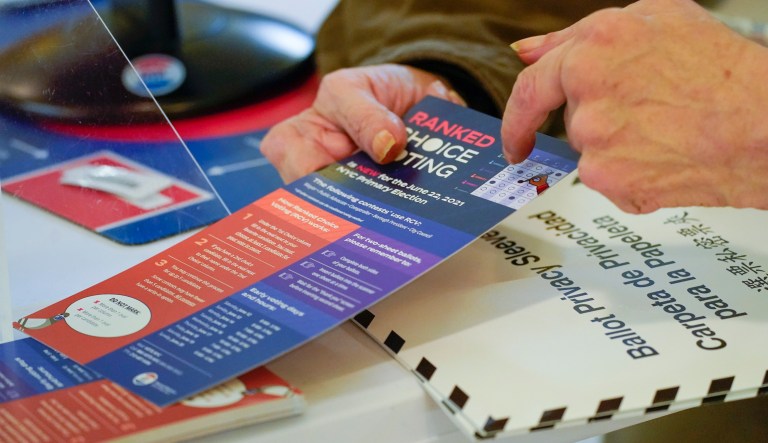 In this Monday, June 14, 2021, file photo, an election worker goes over a ranked choice voting explanation card with a voter before she casts her vote during early voting in the primary election, at the Church of St. Anthony of Padua in the Soho neighborhood of New York.
