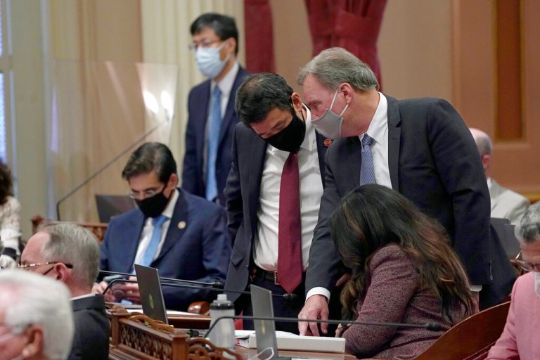 Democratic state senators, standing second from left, Dave Min, of Irvine, Dave Cortese, of San Jose, and Susan Rubio, of Baldwin Park, seated right, huddle as lawmakers debate one of the state budget trailer bills at the Capitol in Sacramento, California, Thursday, July 15, 2021. Among the bills approved was the nation's first state-funded guaranteed income program. The $35 million plan will fund local programs that will provide monthly cash payments to young adults who recently left foster care and pregnant people.