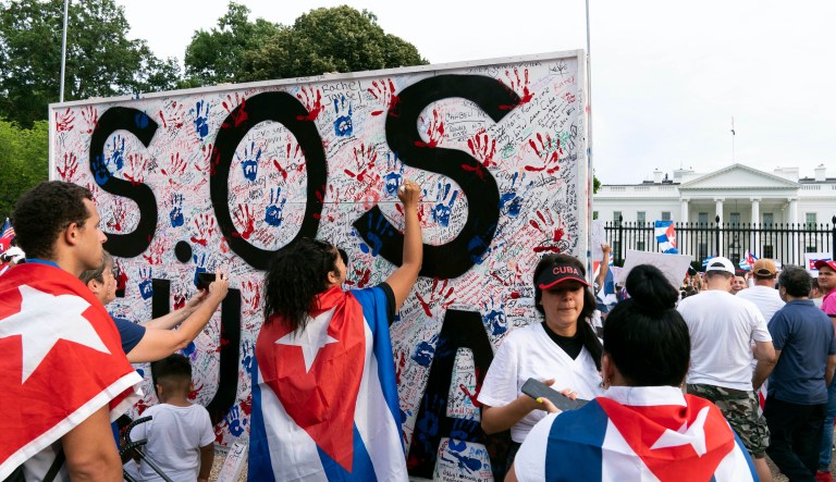 Demonstrators write their solidarity with the Cuban people against the communist government, in a rally outside the White House in Washington, Saturday, July 17, 2021.
