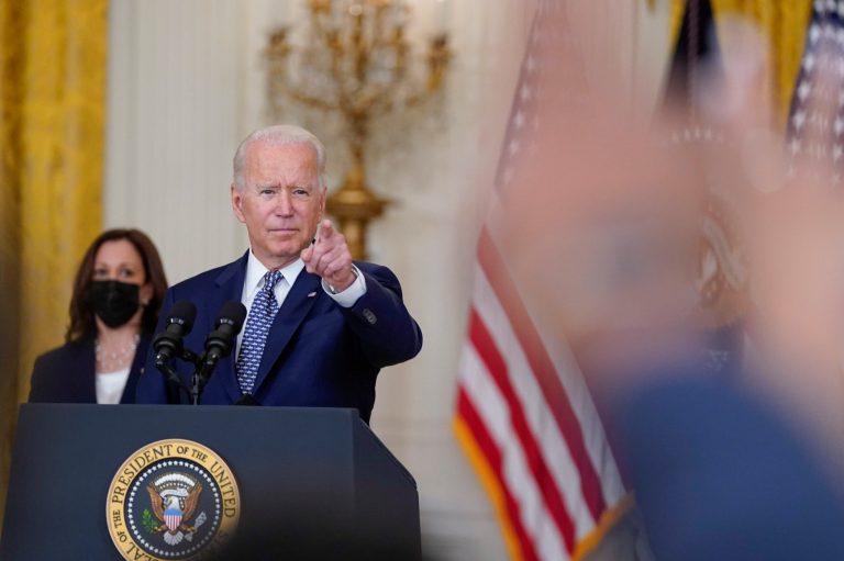 President Joe Biden gestures as he takes questions from members of the media at the East Room of the White House in Washington. Vice President Kamala Harris listens at left. 