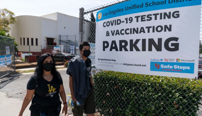 In this April 15, 2021, file photo, parent Rosa Vargas and her son, 9th grade student Victor Loredo, 14, walk home after getting tested at a Los Angeles Unified School District COVID-19 testing and vaccination site in East Los Angeles.