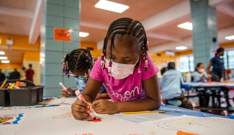Liliana Lambert, 6,  writes down and draws positive affirmations on poster board at P.S. 5 Port Morris, a Bronx elementary school, Tuesday, Aug. 17, 2021 in New York.