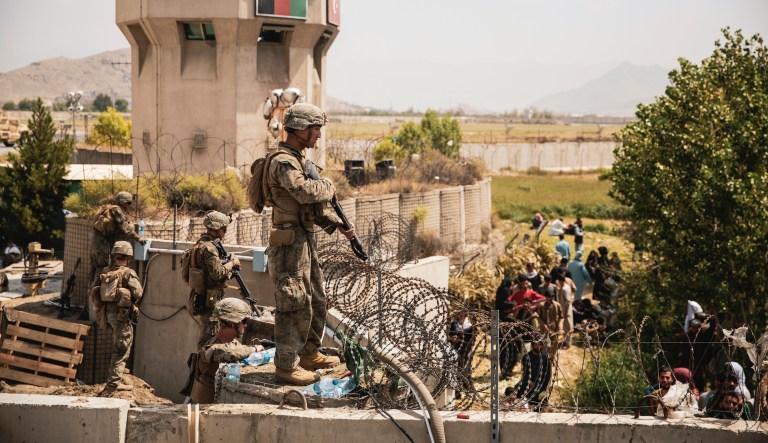In this image provided by the Marine Corps, U.S. Marines assist with security at an Evacuation Control Checkpoint during an evacuation at Hamid Karzai International Airport, Kabul, Afghanistan, Friday, Aug. 20, 2021. 