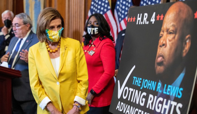 Speaker of the House Nancy Pelosi, D-Calif., looks at a poster of John Lewis during a news conference after the House of Representatives passed the The John Lewis Voting Rights Advancement Act in Washington, on Capitol Hill in Washington, on Tuesday, Aug. 24, 2021.