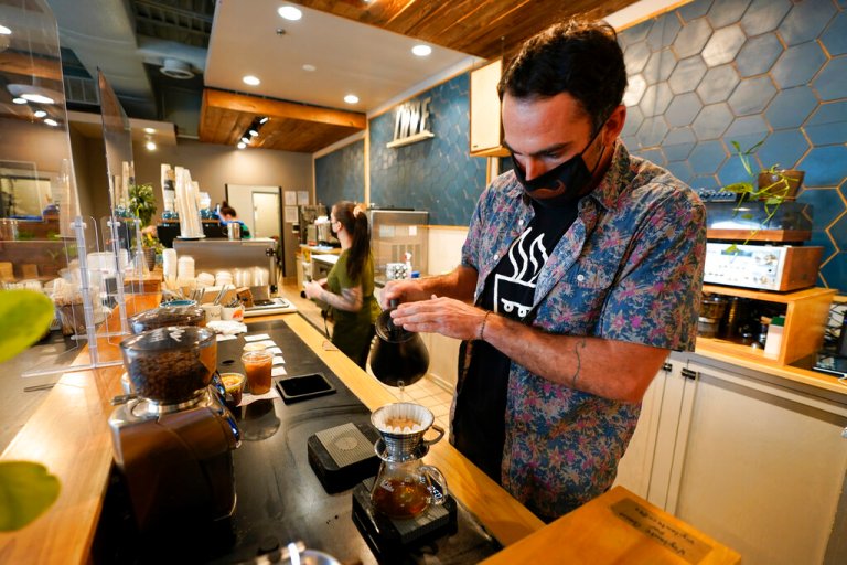 Chris Vigilante makes a dripped coffee for a customer at one of his coffee shops, Wednesday, Sept. 1, 2021, in College Park, Md. A confluence of supply chain problems, drought, frost and inflation all point to the price of your cup of morning coffee going up. 