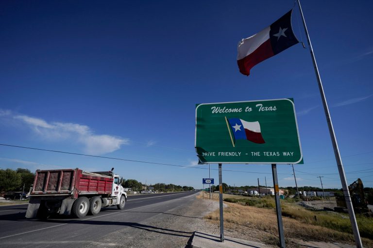 A dump truck drives by a 