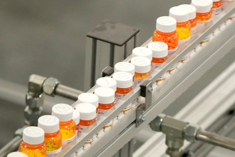 FILE- In this July 10, 2018 file photo, bottles of medications ride on a belt at a mail-in pharmacy warehouse in Florence, N.J. (AP Photo/Julio Cortez, File)